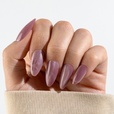 Mão com unhas roxas brilhantes e formato almendrado sobre fundo branco