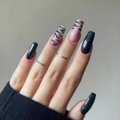 Unhas compridas quadradas com esmalte preto cintilante e padrão zebrado.