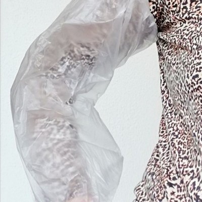 Manga protetora transparente sobre braço com camisa de padrão animal print