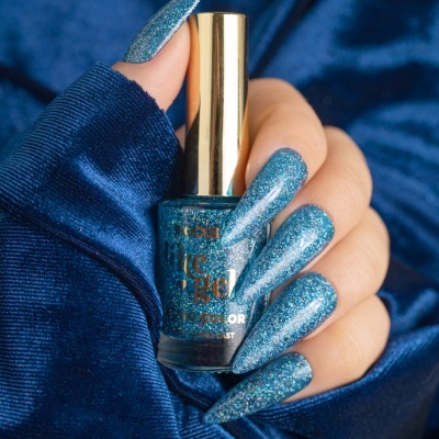 Verniz de unhas azul brilhante com unhas pintadas e fundo de tecido azul