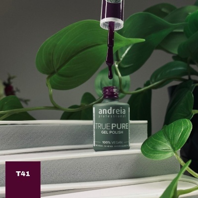 Frasco de verniz gel Andréia roxo rodeado por folhas verdes