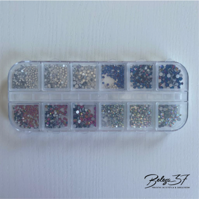 Caixa plástica com pedras brilhantes coloridas para decoração em superfície branca