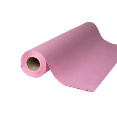 Rolo de tecido ou papel rosa enrolado em tubo de cartão sobre fundo branco