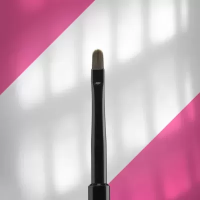 Pincel de maquilhagem preto com cerdas curtas, em fundo branco com triângulos rosa.