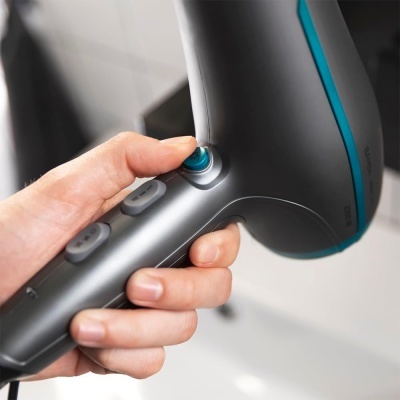 Secador de cabelo cinza com detalhes em azul segurado por uma mão