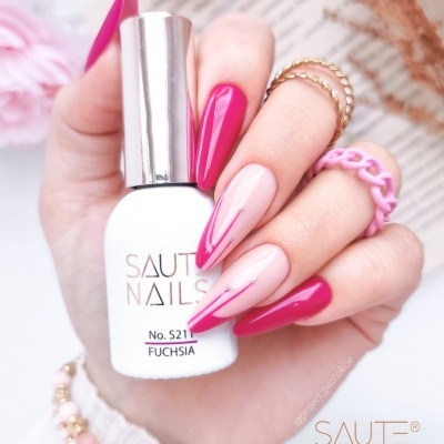 Verniz de unhas SAUTE NAILS rosa fúcsia em mão com unhas pintadas e acessórios rosa e dourados