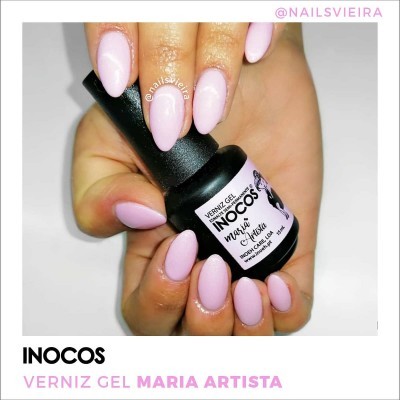 Mão com unhas rosa claro segurando frasco de verniz gel INOCOS Maria Artista