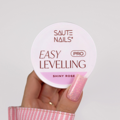 Frasco do produto de unhas SAUTE NAILS EASY LEVELLING PRO SHINY ROSE com unha rosa brilhante e manga rosa às riscas.