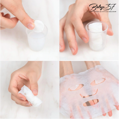 Máscara facial de tecido sendo retirada de copo transparente e aberta por mãos.