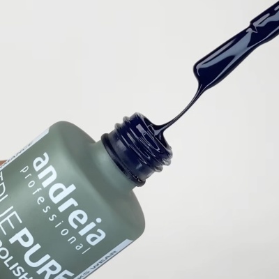 Frasco aberto de verniz para unhas preto com pincel a escorrer verniz.