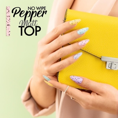 Unhas pintadas em cores pastel com padrão de pontos segurando mala amarela