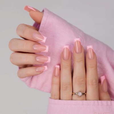 Unhas com manicure francesa rosa em mãos com mangas rosa claro e anel