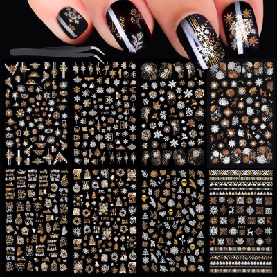 Folhas de decalques para unhas com motivos natalícios e unhas decoradas em preto com desenhos dourados e brancos