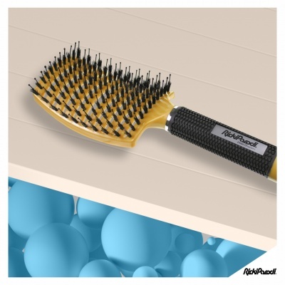 Escova de cabelo amarela com cerdas pretas e cabo texturizado preto sobre superfície clara