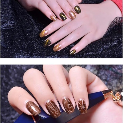 Unhas decoradas com verniz dourado, castanho e preto em fundo escuro