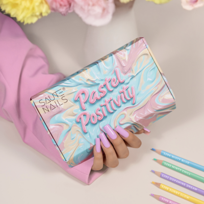 Caixa de verniz para unhas pastel em fundo marmoreado azul, rosa e bege