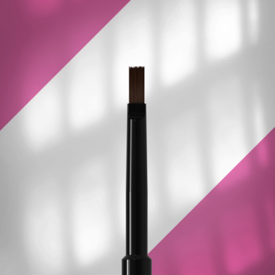 Pincel de maquilhagem preto com cerdas castanhas em fundo branco e rosa