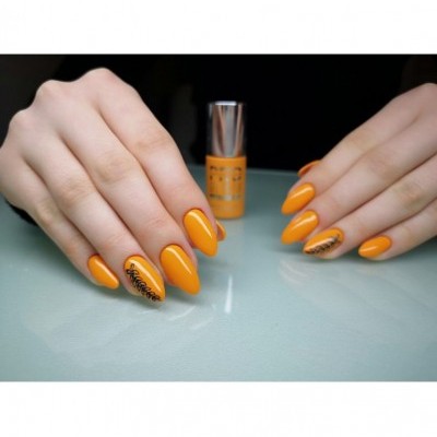 Unhas pintadas de laranja brilhante com decoração preta e texto 'happiness', frasco de verniz laranja ao fundo