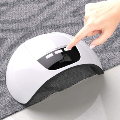 Dispositivo branco para unhas com visor digital e botões sobre toalha cinza