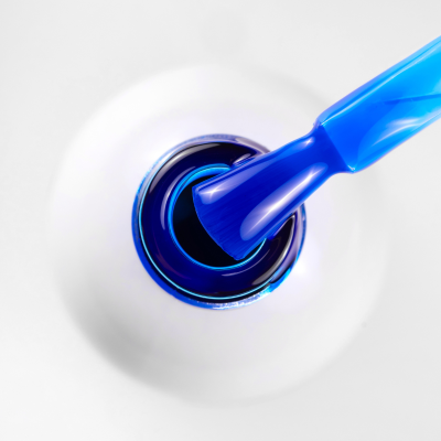 Frasco branco de verniz com pincel azul escuro e esmalte azul escuro