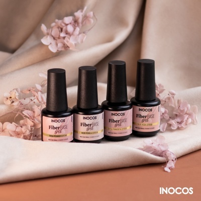 Quatro frascos verniz gel INOCOS Fiber Base em tons neutros sobre tecido bege com flores secas