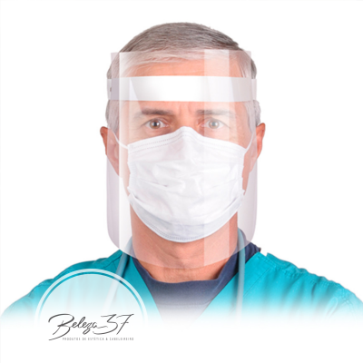 Homem com máscara facial branca e viseira transparente com roupa médica azul