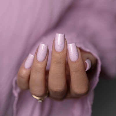 Unhas pintadas de rosa claro com glitter prateado em unhas quadradas