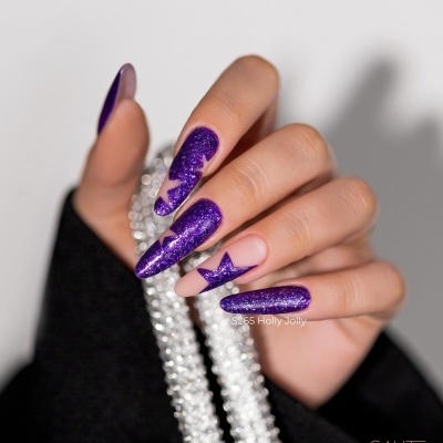 Unhas compridas com verniz roxo com purpurina e uma unha decorada com estrela roxa segurando colar de pérolas
