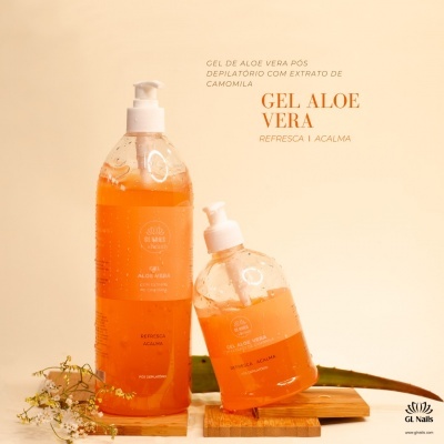 Dois frascos transparentes de gel laranja Gel Aloe Vera com dispensador branco sobre suporte de madeira com flores e folhas de aloe vera.