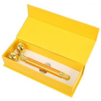 Rolo massajador facial dourado em caixa amarela aberta