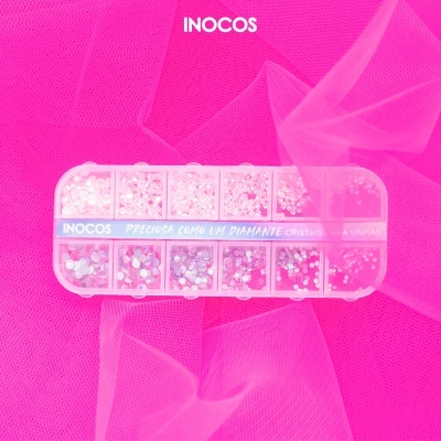 Caixa de cristais decorativos para unhas sobre tecido rosa