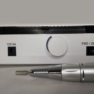 Base branca com controlo e dispositivo prata metálico com ponta texturizada em fundo cinza