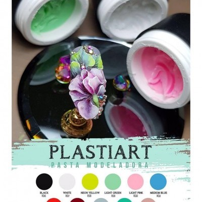 Três potes abertos de pasta modeladora PLASTIART nas cores verde claro, branco e rosa claro com unha decorada em primeiro plano.