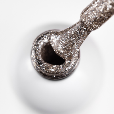 Pincel com verniz glitter prateado a sair de frasco branco com logo SAUTE NAILS