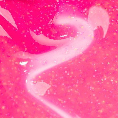 Gel rosa brilhante com partículas douradas em fundo cor-de-rosa