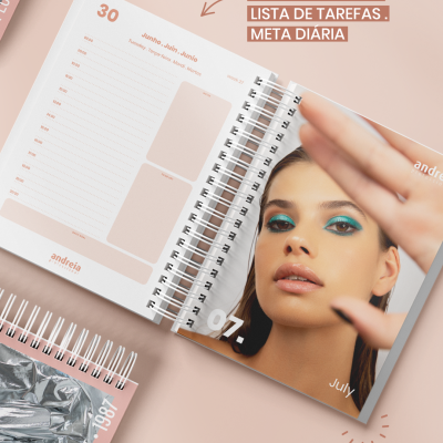 Agendas espiraladas com calendário e fotografia de mulher na página de julho.