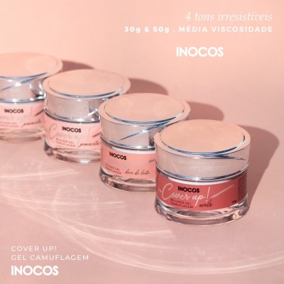 Frascos de gel para unhas INOCOS em tons rosa com tampas prateadas sobre superfície rosa
