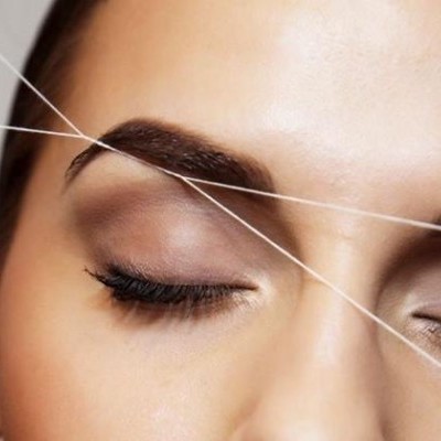 Rosto feminino com sobrancelhas definidas e fios esticados