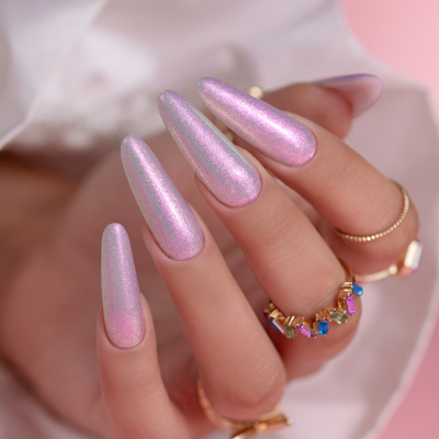 Mão com unhas rosadas iridescentes e anéis coloridos com texto SAUTE NAILS