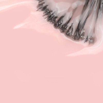 Pincel de maquilhagem com cerdas pretas num fundo cor de rosa