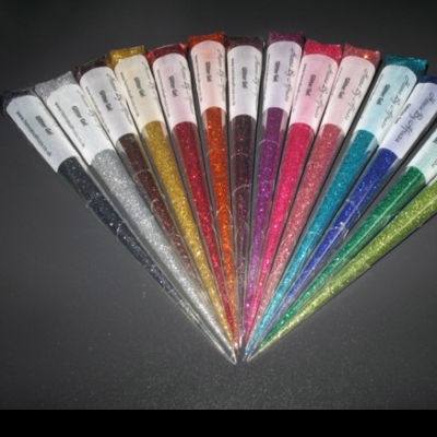 Túbulos cónicos com pó brilhante colorido sobre fundo preto