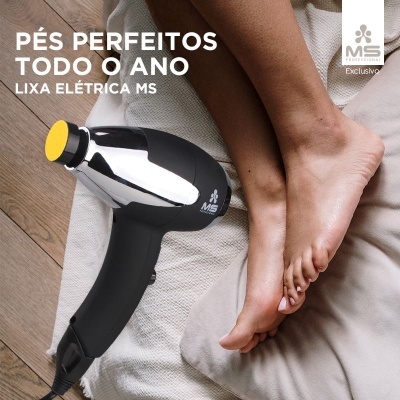 Lixadeira elétrica MS preta e prata ao lado de pés femininos sobre manta branca