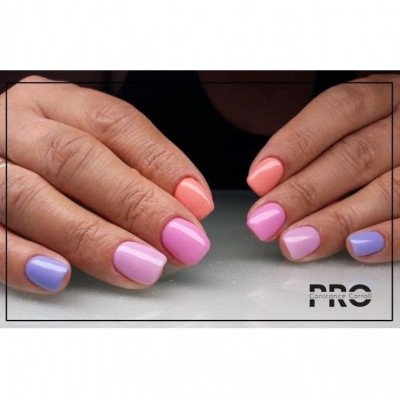 Mãos com unhas coloridas em azul, lavanda, rosa e coral com texto Constance Carroll