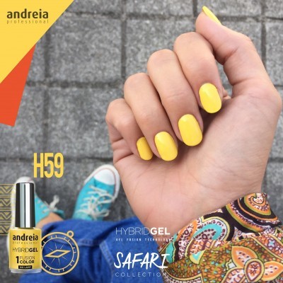 Mão com unhas pintadas de amarelo, garrafa de gel híbrido Andreia H59, fundo com chão de pedra e roupa casual colorida
