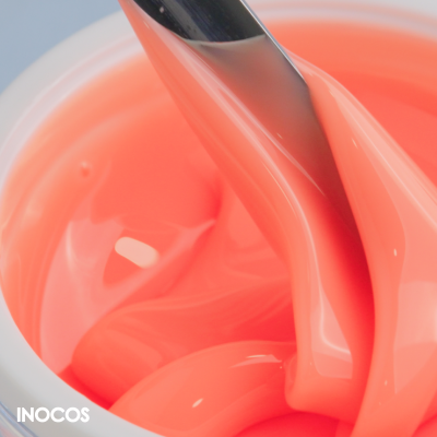 Gel cor de coral em recipiente branco com espátula