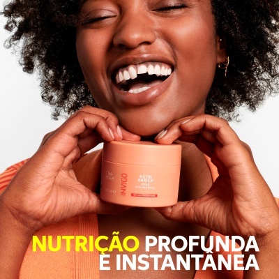 Vaso de creme INVIGO NUTRI ENRICH segurado por mulher sorridente