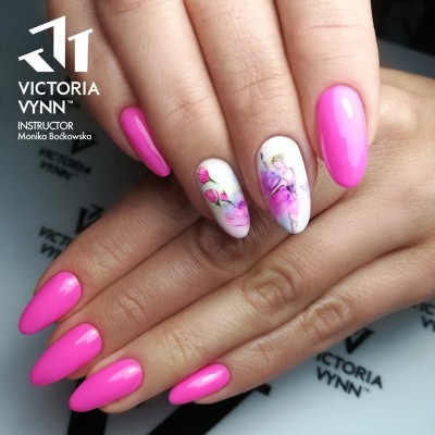 Unhas artificiais rosas com duas unhas decoradas com flores em fundo branco