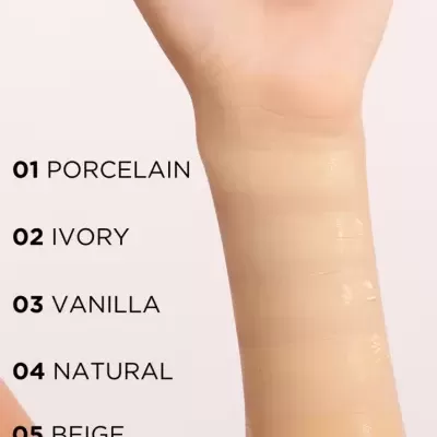 Amostras de bases de maquilhagem em várias tonalidades aplicadas no braço claro.