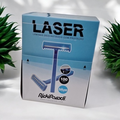 Embalagem azul e branca de lâminas descartáveis de barbear LASER da RickiParodi com plantas verdes ao lado