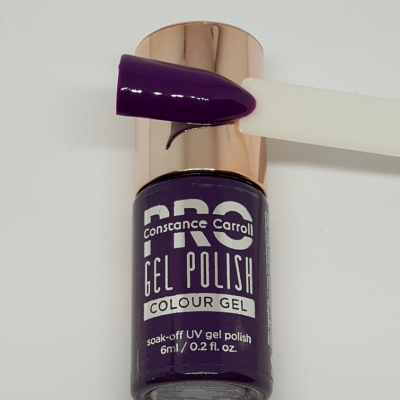 Frasco de verniz gel roxo escuro Constance Carroll com amostra de cor numa unha artificial